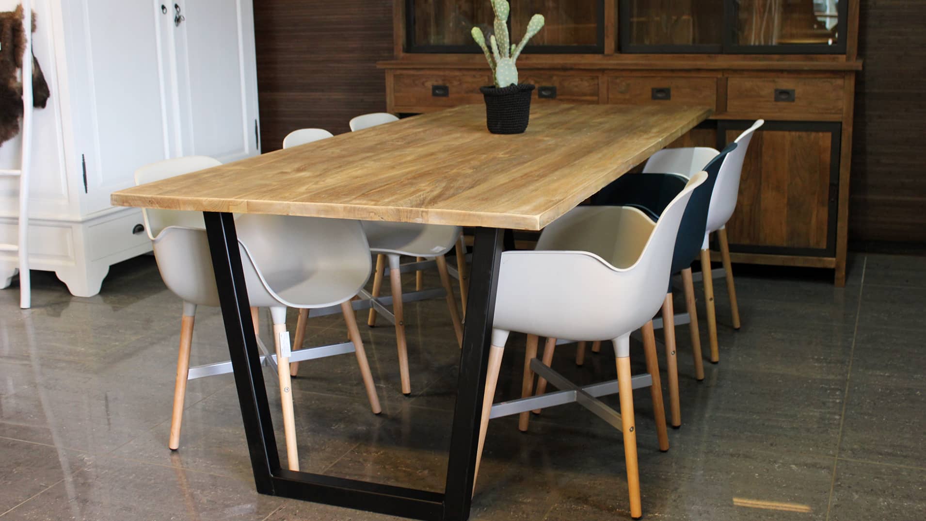 Moderne eetkamertafel met metalen poot en houten blad.